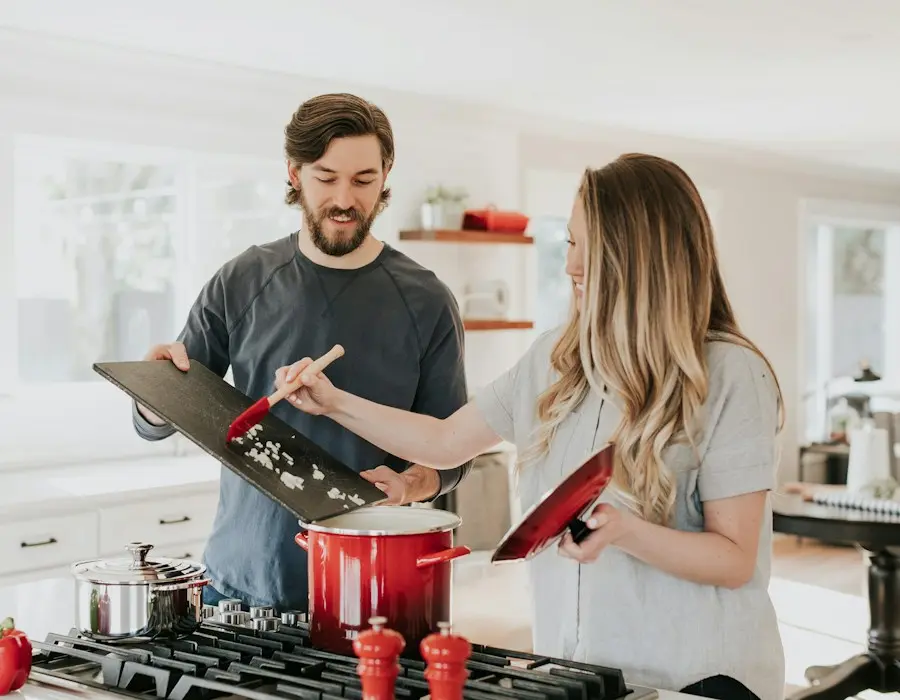 Pareja cocinando en una cocina luminosa